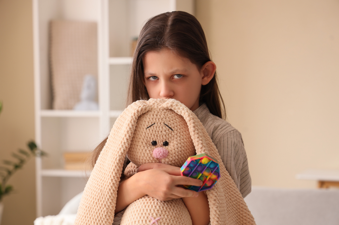Fillette avec une peluche de lapin dans les bras